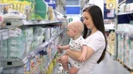 Beautiful Woman With Baby Son Shopping In Supermarket, Young Mother Chooses Food Stock Footage