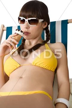 Beautiful woman in bikini with ice cream cone in summer Stock Photos