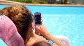 Beautiful Woman Browsing the Web near Swimming Pool. Tanned Girl. Phone HD Footage