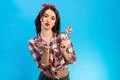 The beautiful woman with a candy blowing an air kiss on the blue background Photo