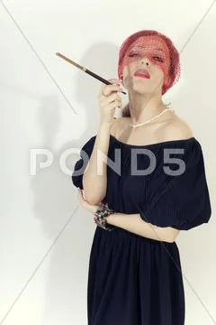 Beautiful woman with cigarette in mouthpiece in veil Stock Photos