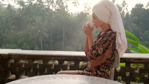 Beautiful woman with cup of coffee tea enjoying the view from the balcony,Bali Stock Footage