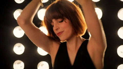 Beautiful woman dancing in front of a wall of lights Video stock 103581153