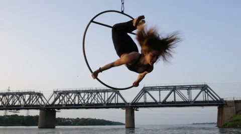 Beautiful woman doing acrobatic elements hanging on a bridge Stock Footage 64598764
