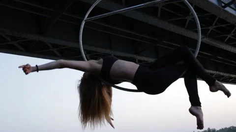 Beautiful woman doing some acrobatic elements on aerial ho hanging on the bridge Stock Footage 64598997