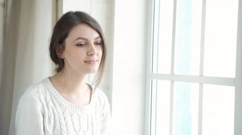 Beautiful woman drinking coffee in the morning sitting by the window Stock Footage 59348507