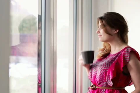Beautiful woman in drinking tea by the window at home NTSC Stock Footage