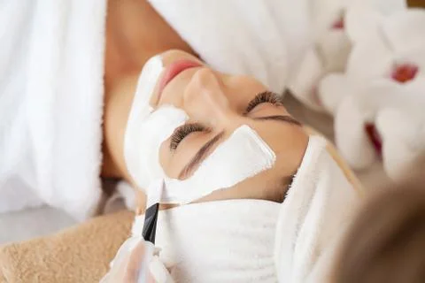 Beautiful woman with facial mask at beauty salon Stock Photos