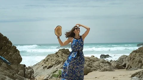 Beautiful woman feels free and happy while standing on the beach, steadycam shot Stock Footage