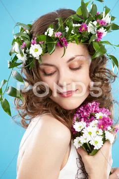 Beautiful woman in floral wreath looking aside Stock Photos