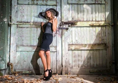 Beautiful woman with hat in short black summer dress Stock Photos