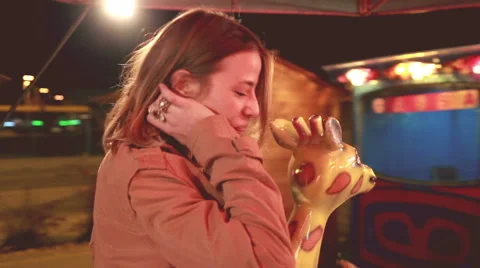 Beautiful woman having fun riding carousel in amusement park Stock Footage 59556219