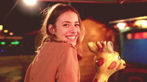 Beautiful woman having fun riding carousel in amusement park Stock Footage 59556225