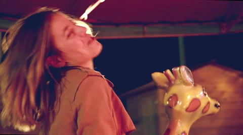 Beautiful woman having fun riding carousel in amusement park Stock Footage 59556242