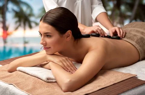 Beautiful woman having hot stone massage at spa Stock Photos
