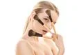 The beautiful woman holding cosmetic brushes on the white background Photo