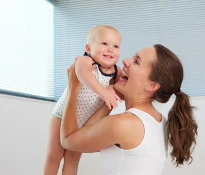 Beautiful woman holding cute smiling baby Foto stock