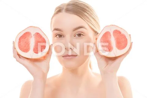 The beautiful woman holding a grapefruit on the white background Stock Photos