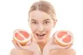 The beautiful woman holding a grapefruit on the white background Photo