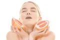 The beautiful woman holding a grapefruit on the white background Photo
