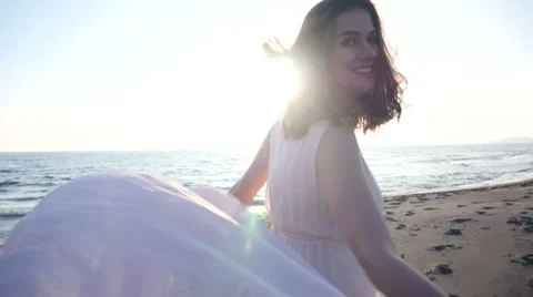 Beautiful woman holding light fabric on the beach and enjoy the sunset Stock Footage