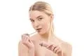 The beautiful woman holding a lip gloss on the white background Photo