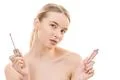 The beautiful woman holding a lip gloss on the white background Photo