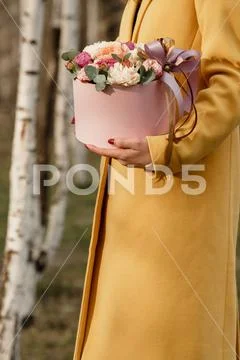 Beautiful woman holding pink box with flowers. Gift to Women's Day. Agency Stock Photos