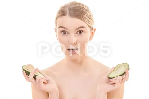 The beautiful woman holding two halves of a avocado on the white background Stock Photos