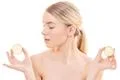 The beautiful woman holding two halves of a lemon on the white background Photo