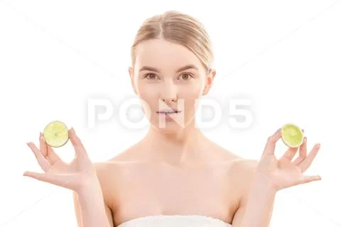The beautiful woman holding two halves of a lime on the white background Stock Photos