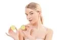 The beautiful woman holding two halves of a lime on the white background Photo
