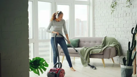 Beautiful Woman Is Hoovering The Floor At Home Using Modern Vacuum