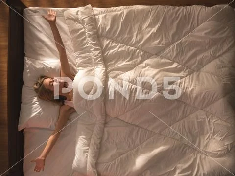 The beautiful woman lay on the bed and gesture. View from above Stock Photos