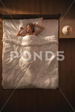 The beautiful woman lay on the bed and gesture. View from above Stock Photos