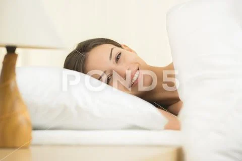 The beautiful woman lay on the bed and smile Stock Photos