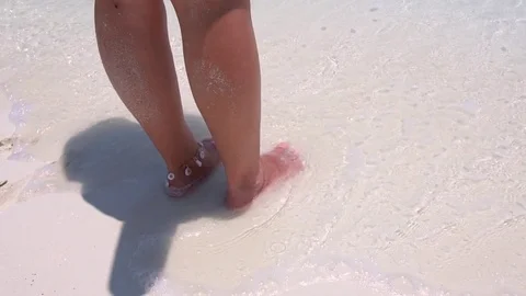 Beautiful woman legs, walking on the beach Stock Footage