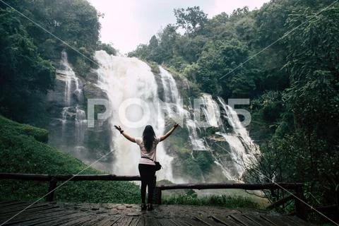 Beautiful woman looking at big waterfall after hiking in Chiang Mai (Thailand Stock Photos