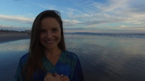 A beautiful woman looking into the camera while standing on the beach in Santa Stock Footage 68137393