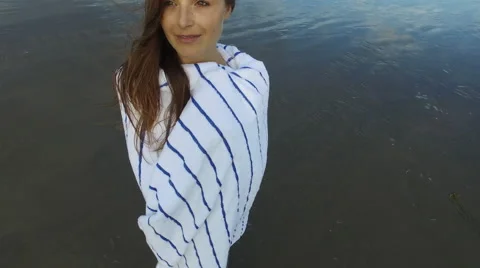 A beautiful woman looking into the camera while standing on the beach in Santa Stock Footage 68137643