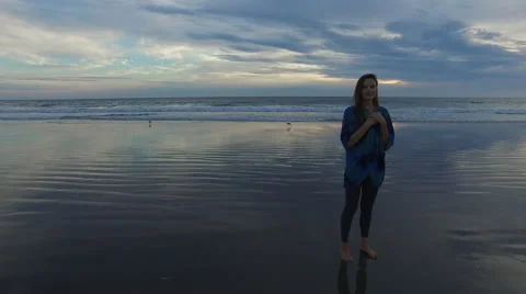 A beautiful woman looking into the camera while standing on the beach in Santa Stock Footage 68137742