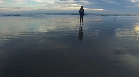 A beautiful woman looking into the camera while standing on the beach in Santa Stock Footage 68137822