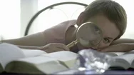 Beautiful Woman Looking Through A Magnifying Glass At Home Stock Footage