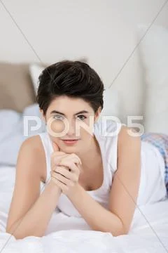 Beautiful woman lying on the bed Stock Photos