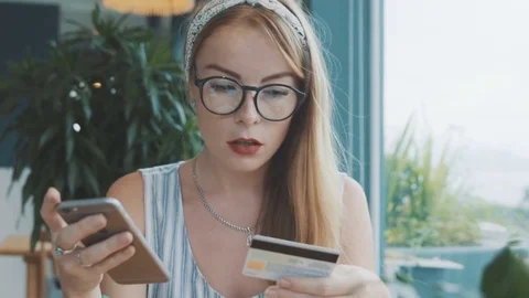 Beautiful woman make payment with credit card and mobile phone. Stock Footage