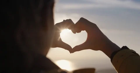 Beautiful Woman making heart shape with hands at sunset Girl holding up love Stock Footage