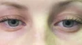 beautiful woman opens and closes her blue eyes - macro HD Footage