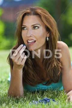 Beautiful woman outside eating blueberries and smiling Stock Photos