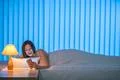 The beautiful woman with phone lay on the bed. Evening night time Photo