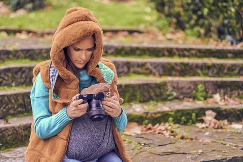 Beautiful woman photographer carrying her son sitting on the steps of a park Stock Photos